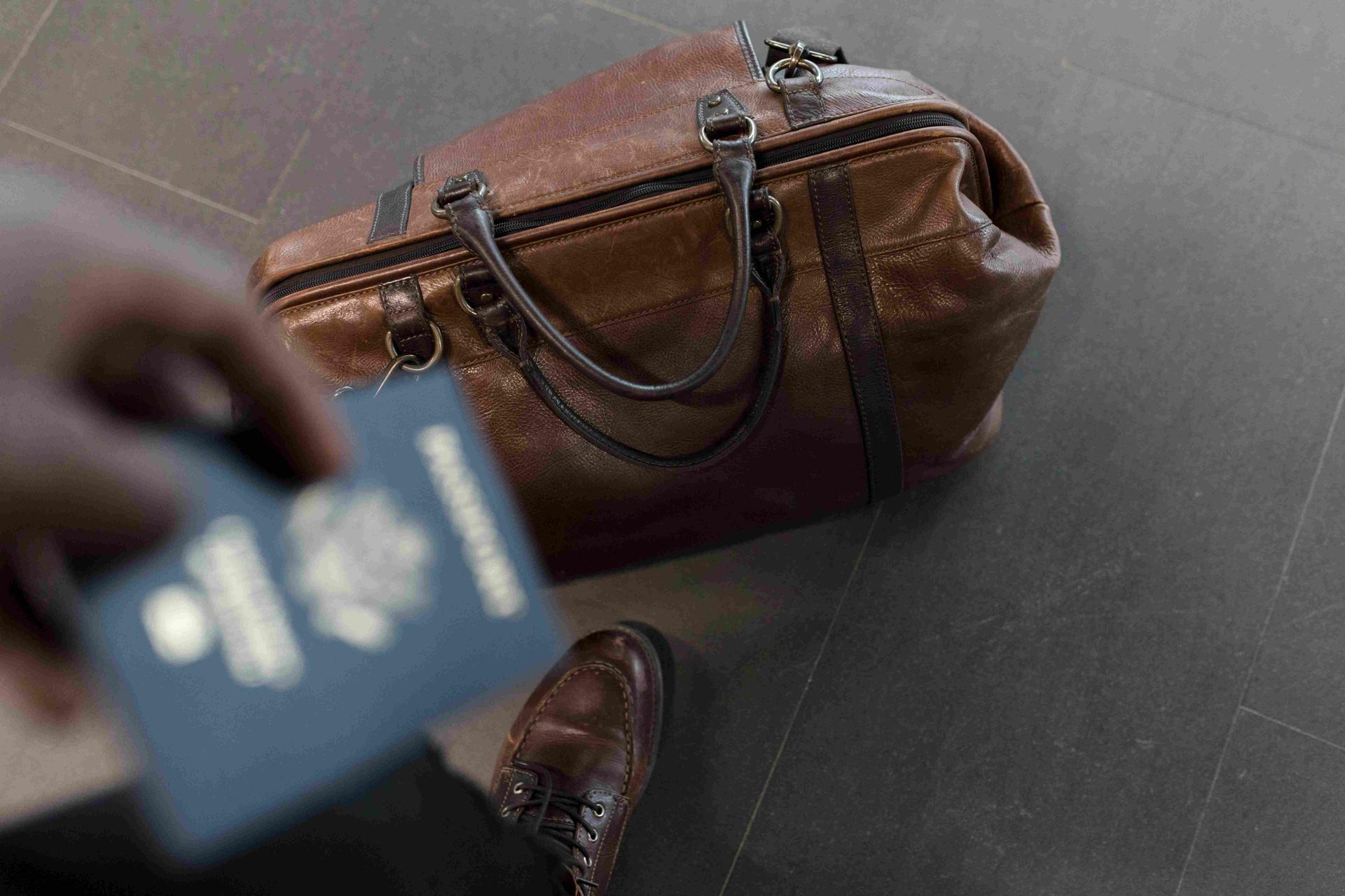 Imgage d'une personne prête à partir avec son passeport et ses bagages
