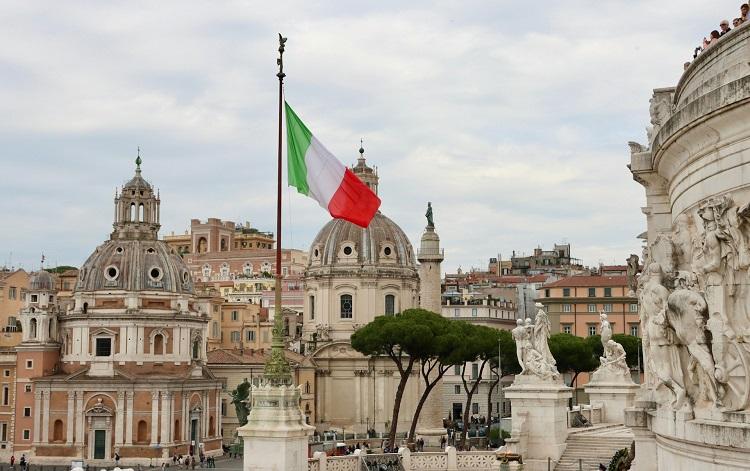 drapeau italien flotte devant des monuments de Rome
