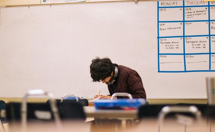 un lycéen étudie dans une salle de classe