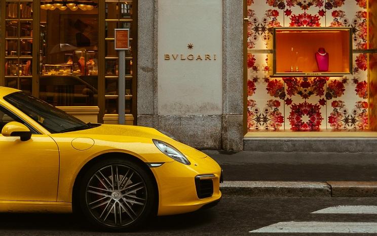 voiture de sport de luxe jaune garée devant une boutique