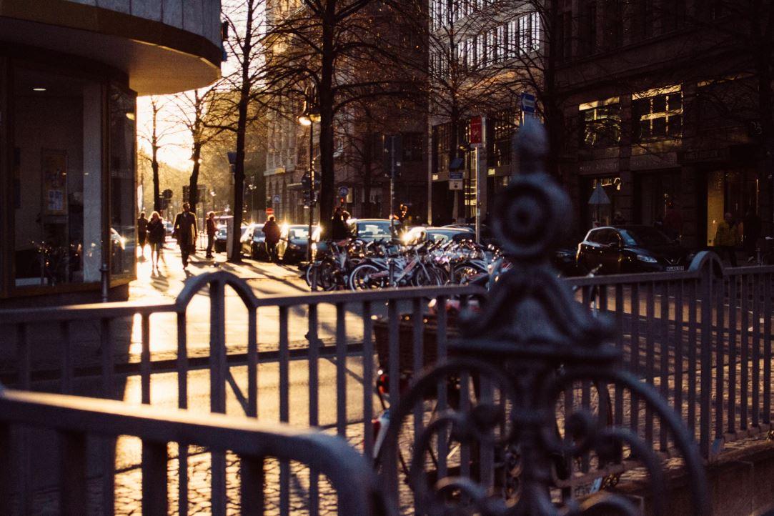 Vue d'une rue de Francfort avec le soleil couchant et des véhicules stationnés.
