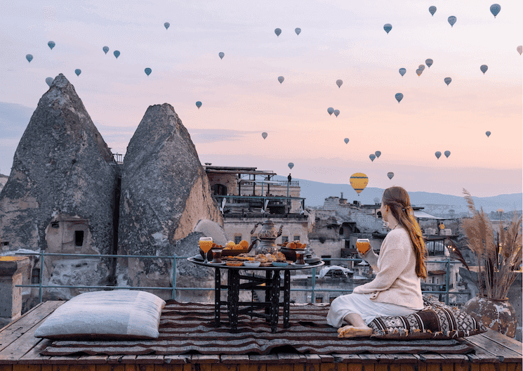 Petit-déjeuner traditionnel avec vue sur les montgolfières au lever du soleil en Cappadoce, Turquie.