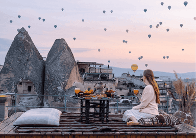 Petit-déjeuner traditionnel avec vue sur les montgolfières au lever du soleil en Cappadoce, Turquie.