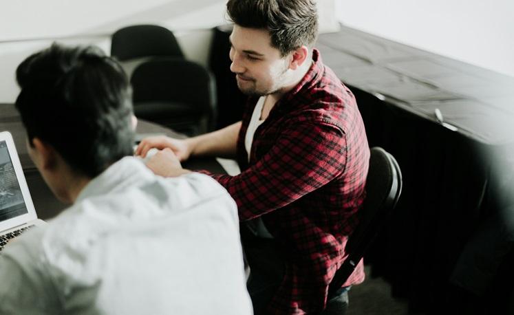 deux jeunes hommes travaillent sur un ordinateur