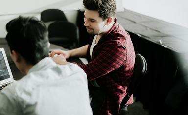 deux jeunes hommes travaillent sur un ordinateur