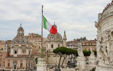 drapeau italien flotte devant des monuments de Rome