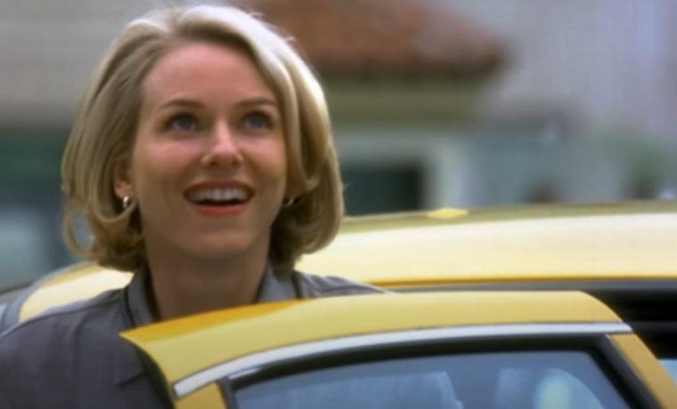 femme blonde devant un taxi jaune.