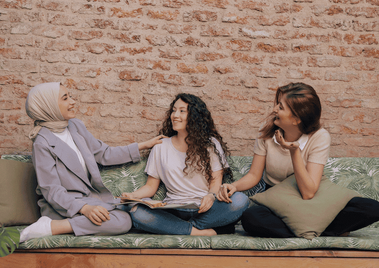 Trois femmes souriantes collaborant dans un projet coopératif en Turquie, illustrant la solidarité et l'entraide féminine.