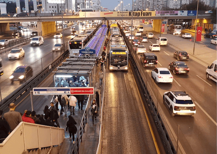 Vue d'une station Métrobus bondée à Istanbul avec des passagers montant et descendant, représentant les défis du transport public et les hausses de tarifs en 2025.