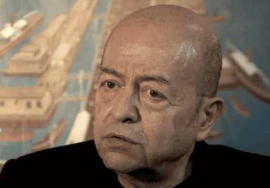 Selim İleri, écrivain turc, photographié avec un décor évoquant Istanbul.