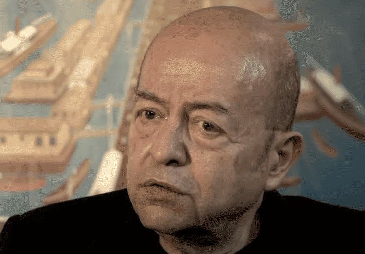 Selim İleri, écrivain turc, photographié avec un décor évoquant Istanbul.