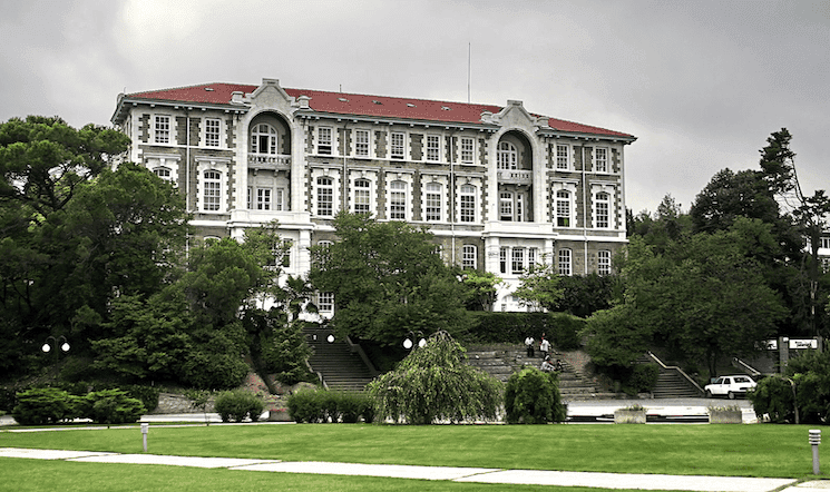 ue emblématique du bâtiment principal de l’Université Boğaziçi à Istanbul, entouré de verdure, symbole d’excellence académique en Turquie.