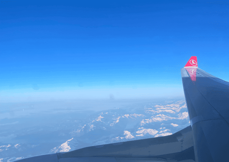 Vue d'une aile de Turkish Airlines survolant une chaîne de montagnes, représentant les nouvelles destinations ouvertes en 2025.