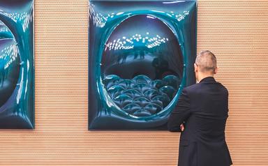 une homme regarde une oeuvre exposée