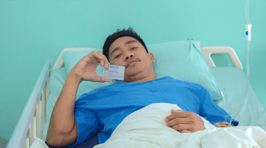 un homme tenant sa carte de sécurité sociale