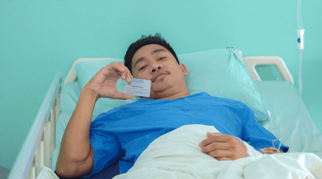 un homme tenant sa carte de sécurité sociale