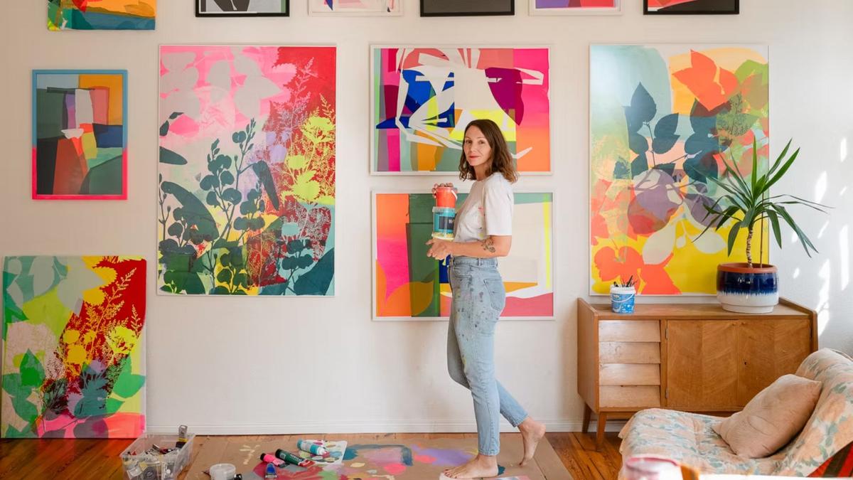 Adeline Meilliez devant un mur d'oeuvres colorées