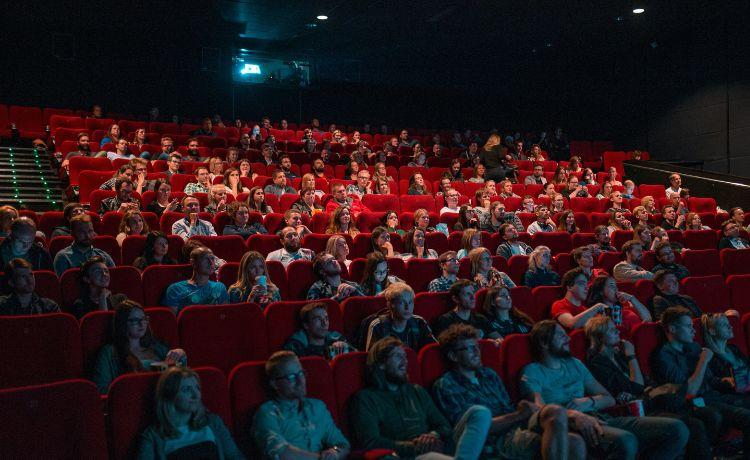 des spectateurs sont assis dans une salle de cinéma
