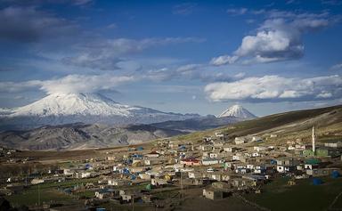 Vue du Mont Ağrı en Turquie avec un village au premier plan et des paysages enneigés.