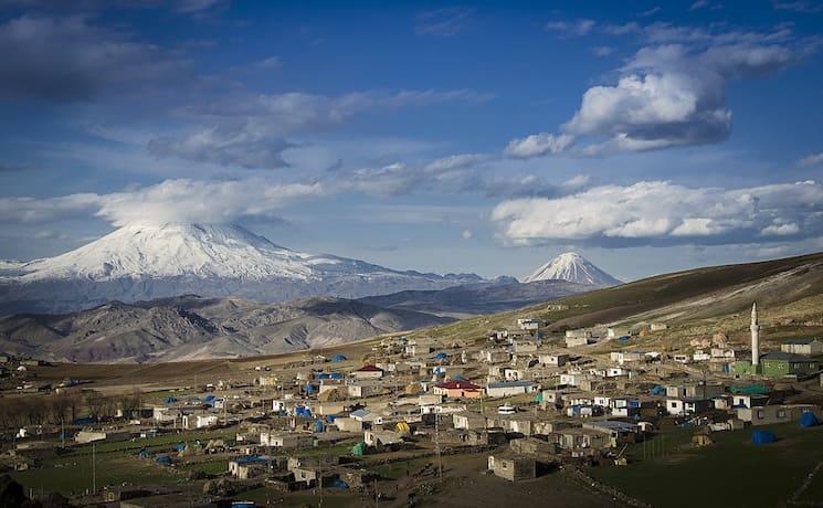 Vue du Mont Ağrı en Turquie avec un village au premier plan et des paysages enneigés.