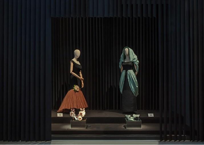 Robes haute couture exposées sur fond noir