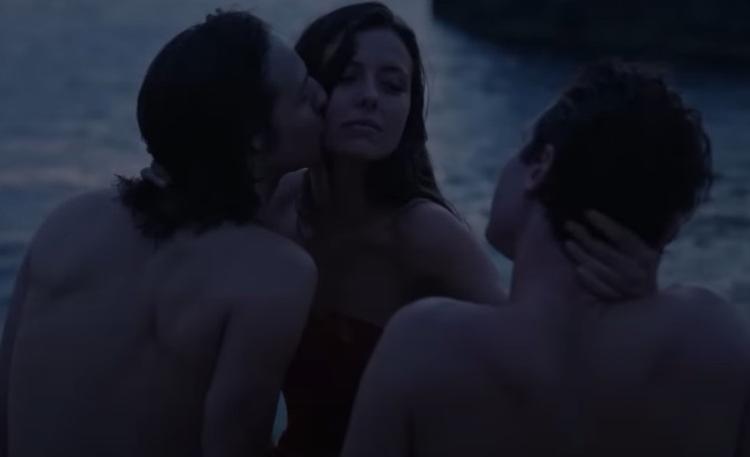 trois personnes s'embrassent devant la mer