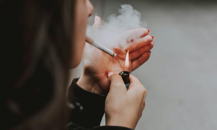 une femme en train de fumer une cigarette