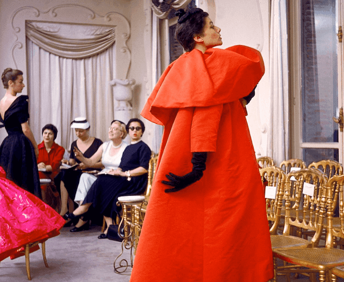 mannequin avec une robe rouge de créateur lors d'un défilé dans les années 1950