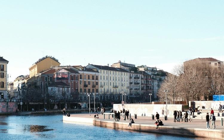 des gens au bord d'un canal dans la ville