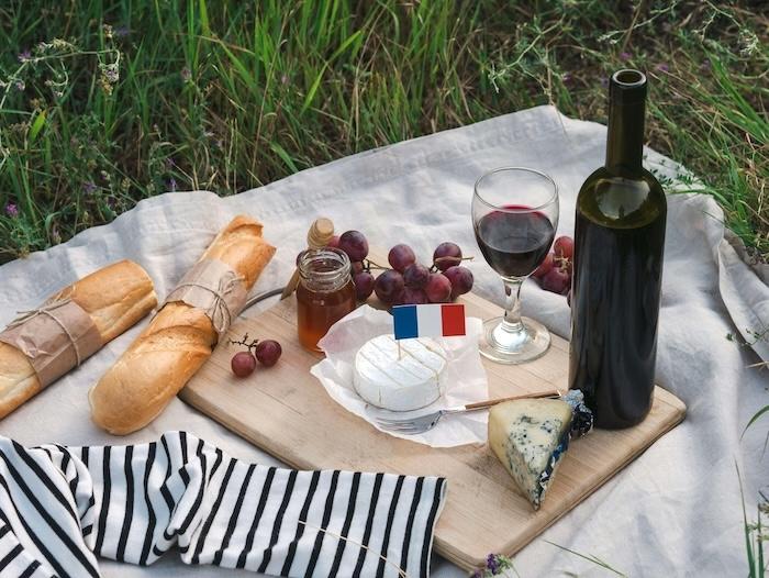 pique nique traditionnel avec produits français comme camembert baguette vin rouge et raisin