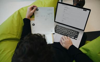 une personne fait des factures sur son ordinateur