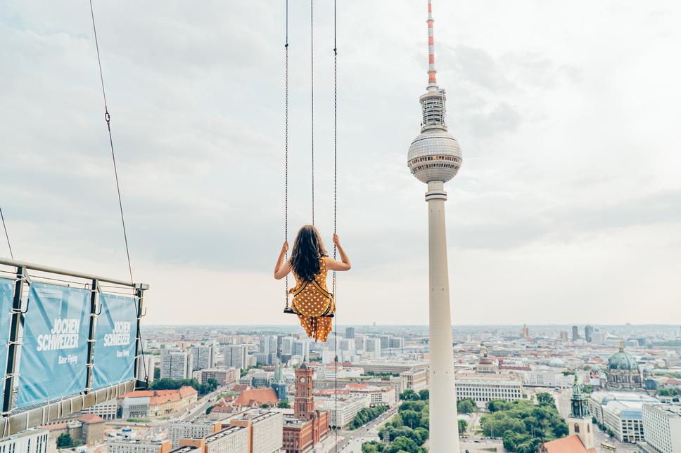 Femme sur une balançoire avec la tour de la télévision