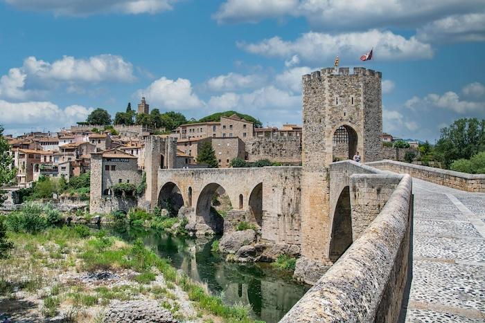 pont roman et tours de pierre medievales à l'entree du village de besalu en catalogne au printemps