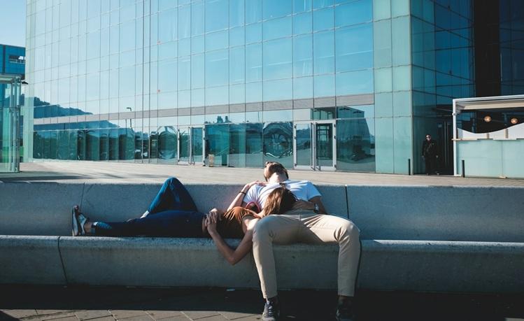 un homme et une femme allongés sur des escaliers en béton font la sieste