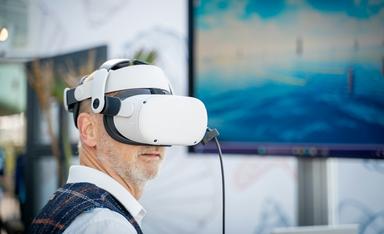 un homme porte un masque de réaité virtuelle devant un ordinateur