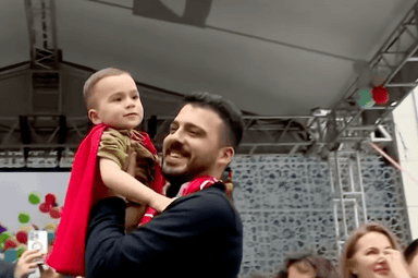 Le petit Ali, 3 ans, porté par son père lors du lâcher de ballons à Sancaktepe, Istanbul, mai 2025