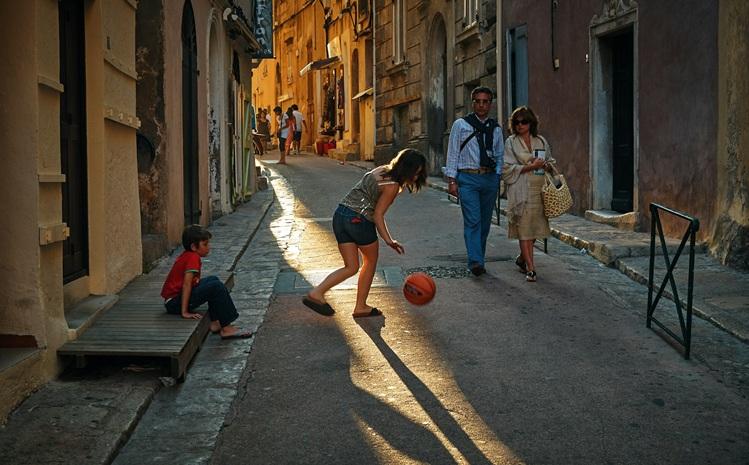 une fille joue avec un ballon dans la rue