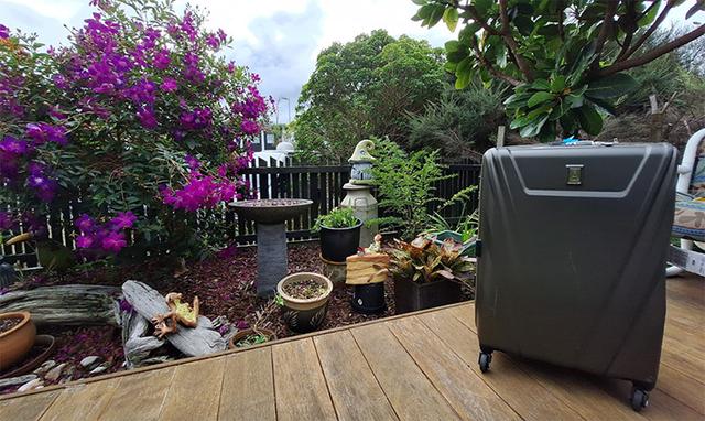 Valise grise posée sur une table dans un jardin