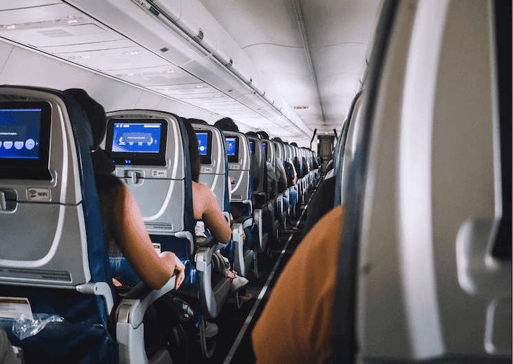 Des passagers restent assis dans un avion après l'atterrissage, ceintures attachées