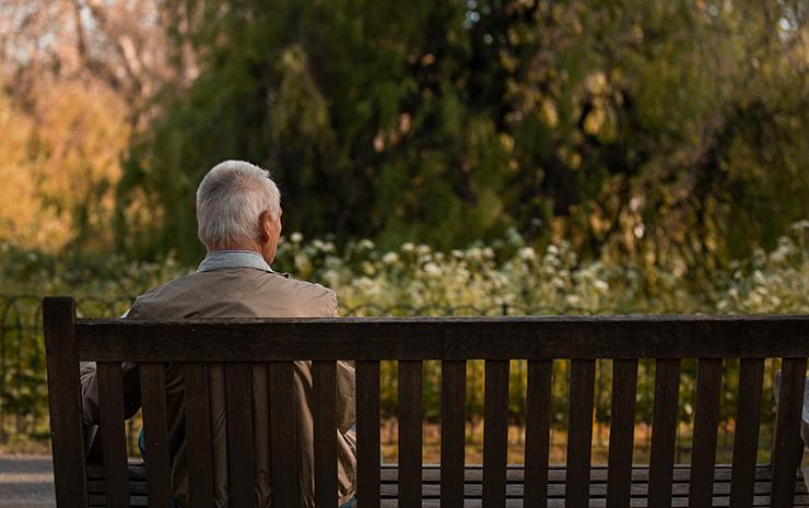 vista-traseira-velho-sentado-no-banco_Freepik