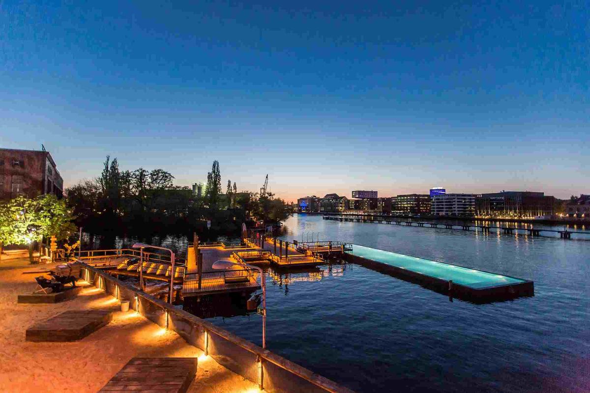 Le Badeschiff au coucher du soleil, un long bassin sur la Spree et des terrasses sur le fleuve