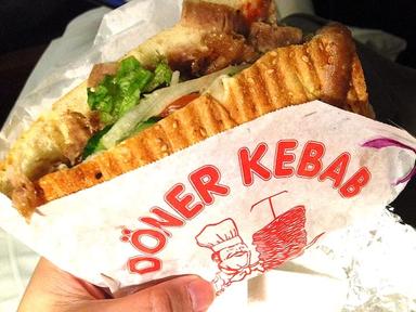 Logo du döner kebab imprimé sur un emballage alimentaire, avec un sandwich partiellement entamé