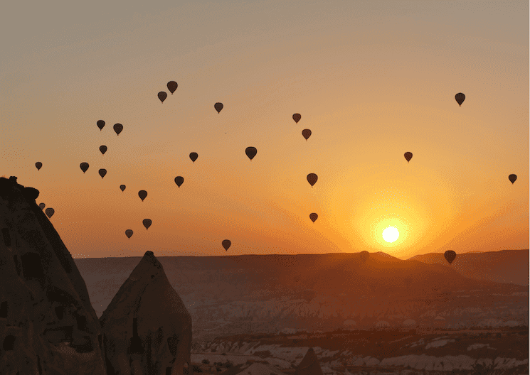 Montgolfières au lever du soleil en Cappadoce, symbole de mémoire et de transmission en Turquie.