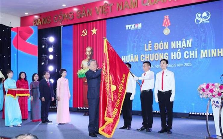 Le Secrétaire général du Parti, Tô Lâm, attache l’Ordre de Hô Chi Minh au drapeau traditionnel de la VNA.