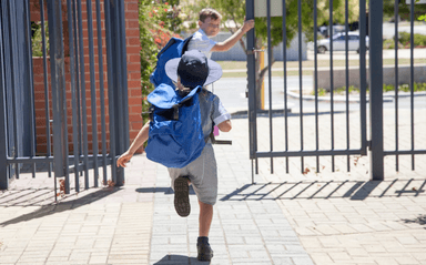 Un enfant court pour rattraper un ami au portail