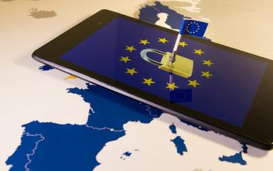 Tablette avec un cadenas. Drapeau de l'Union européenne planté dessus. Le tout sur un fond de carte de l'Europe