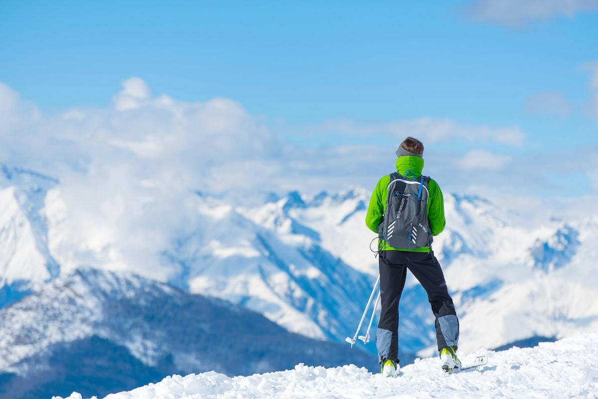 une dame regarde la vallée de ski un jour de beau temps dans les Alpes