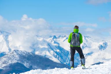 une dame regarde la vallée de ski un jour de beau temps dans les Alpes