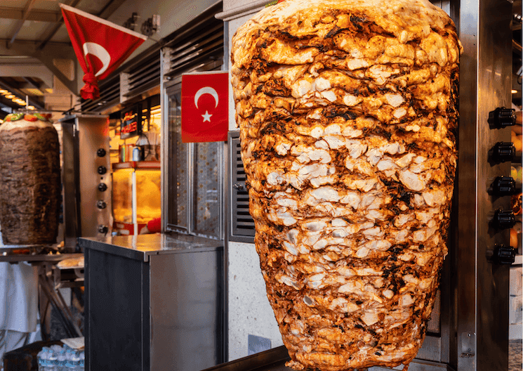 Broche verticale de döner kebap dans une rue de Turquie, devanture décorée de drapeaux turcs