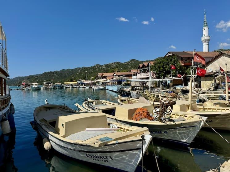 Barques de pêche et maisons à Kale Üçağız, village turc distingué par l’ONU Tourisme en 2025.